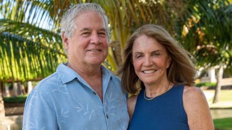 A retired couple savoring the tranquility of palm trees, capturing the essence of a tropical escape.